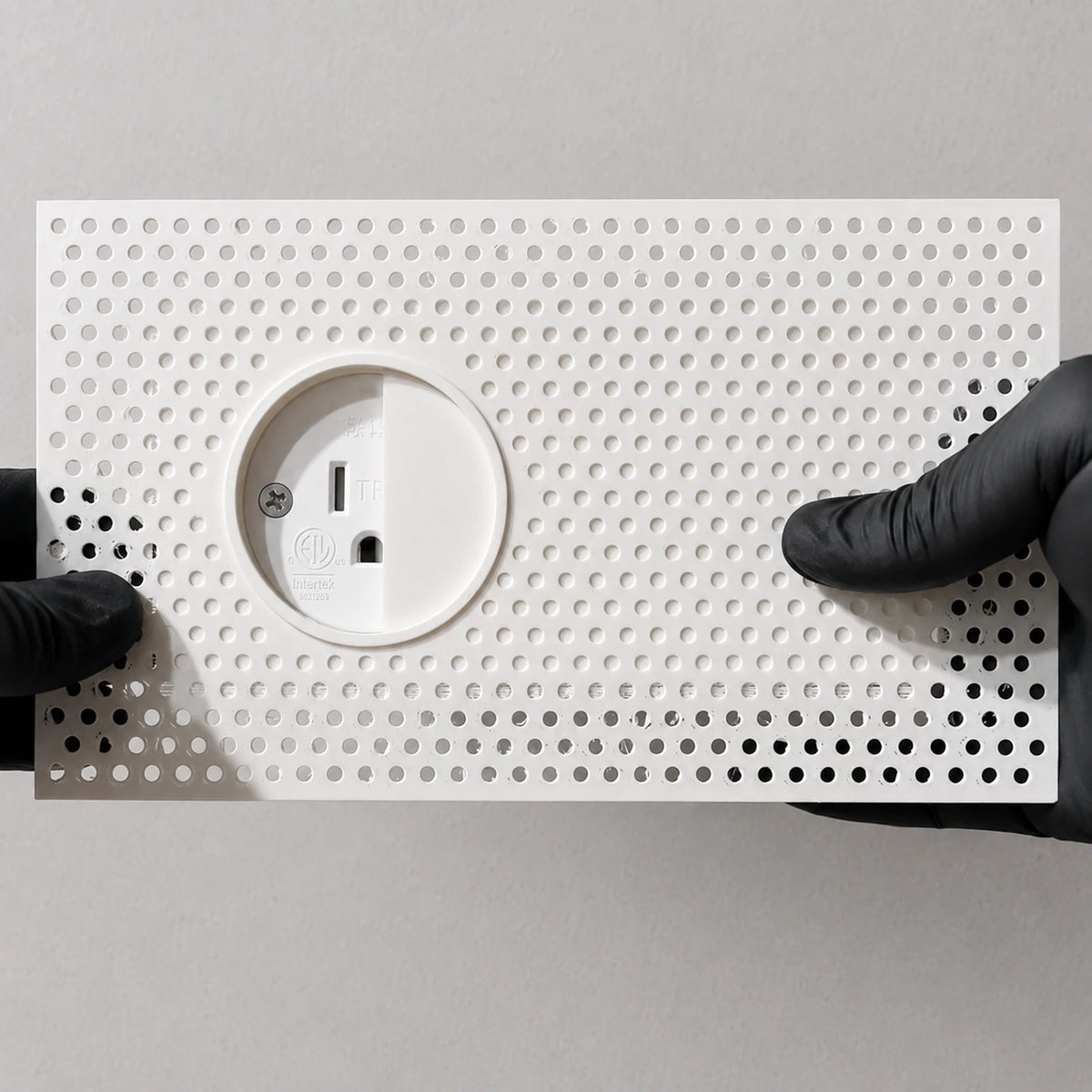 Concealed outlet enclosure and sliding lid before installation, showing the perforated mud-in flange