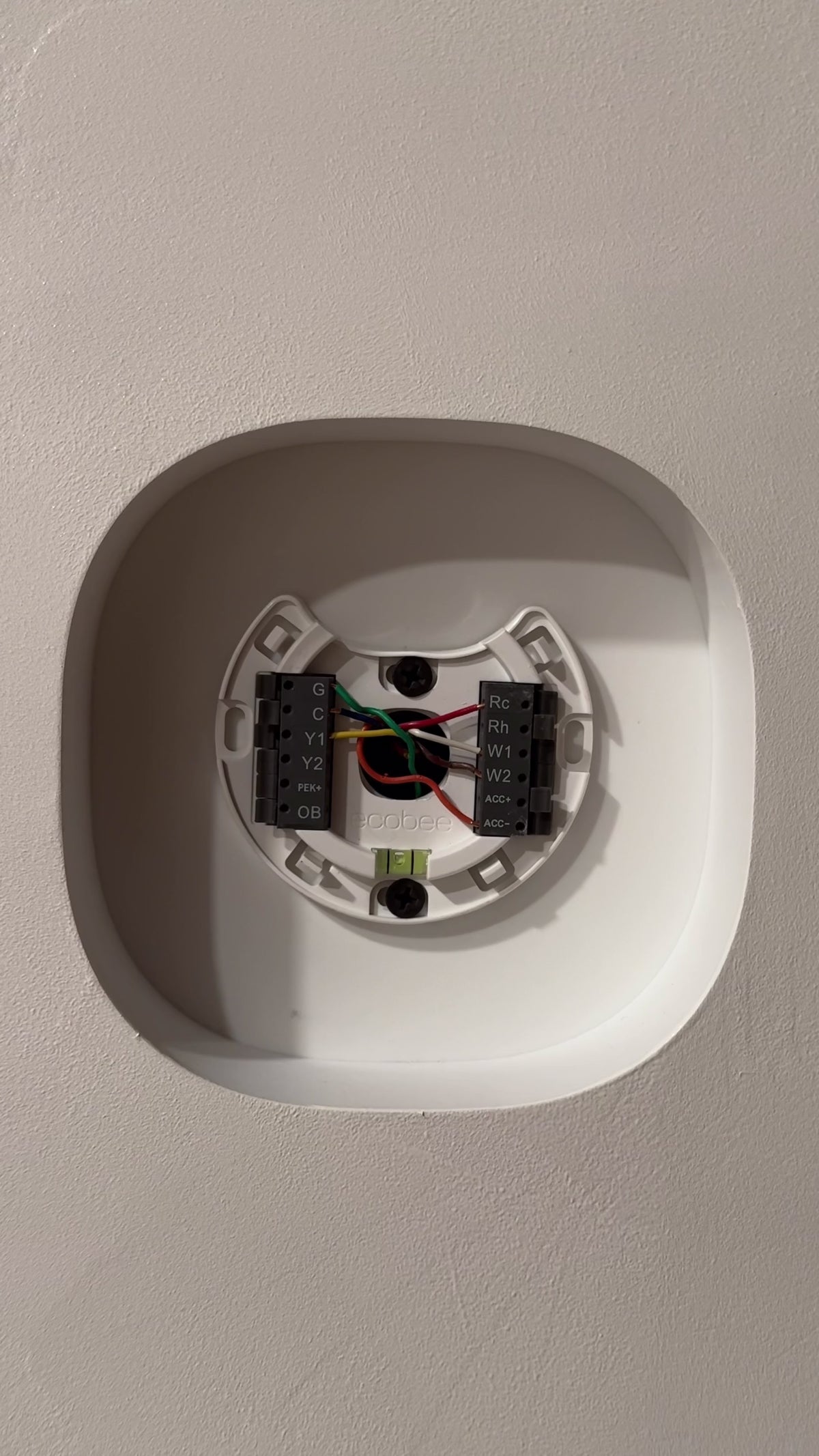 Installation fit demonstration: ecobee Smart Thermostat Premium fitted into the finished white contoured drywall niche
