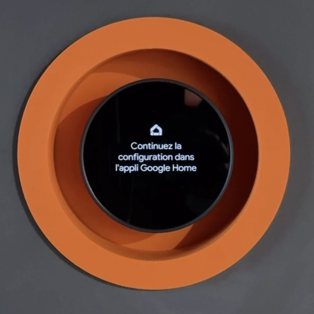 Google Nest thermostat installed in an orange recessed drywall mount with a solid visible frame