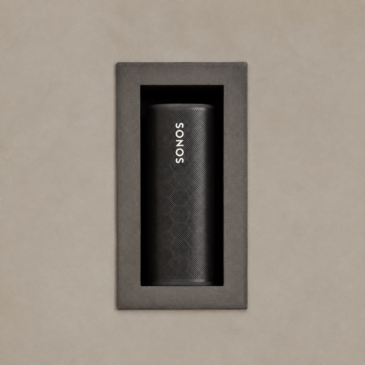 Sonos Roam speaker installed vertically in a recessed drywall niche with a visible dark frame